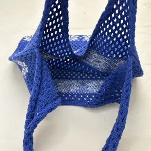 Nahansicht der blauen gestrickten Netz-Umhängetasche mit hohler Struktur und dem Gewebe.
