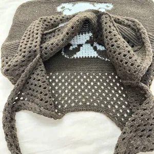 Detailansicht der braunen, geflochtenen Schultertasche mit feiner Häkelstruktur und Hasenmotiv.