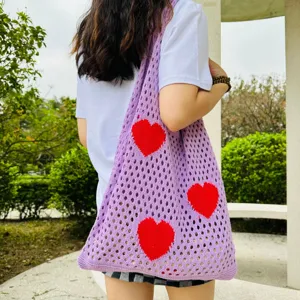 Lila Strick-Tasche mit rotem Herzmuster, lässige hohle Umhängetasche Detailansicht.