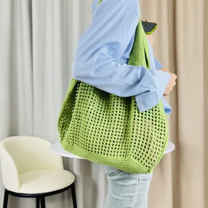 Detailaufnahme einer grünen Strick-Tasche, gehäkelte Mesh-Umhängetasche für Damen.