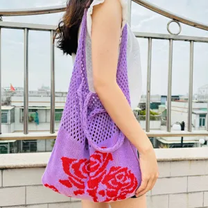 Detailansicht der gestrickten Tragetasche aus lila Stoff mit auffälligem roten Rosenmuster.
