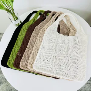 Nahaufnahme von mehrfarbigen Strick-Netz-Tote-Taschen ordentlich auf einem weißen runden Tisch.
