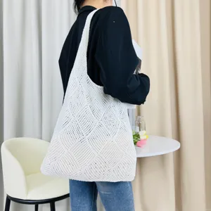 Detailansicht der weißen Strick-Hohltasche mit feiner Netzstruktur im schönen Lifestyle.