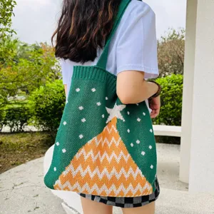 Detailansicht der grünen Stricktasche mit weihnachtlichem Baummotiv und praktischem Schulterriemen.