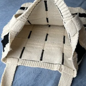 Nahaufnahme der gewebten Stricktextur und der Innenstruktur dieser stilvollen Handtasche.