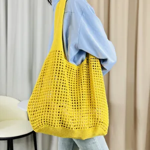 Gelbe Strick-Häkel-Umhängetasche, eine lässige gewebte Handtasche mit Lochmuster.