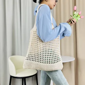 Detailansicht der eleganten beigen gestrickten Netztasche mit feiner offener Webstruktur.