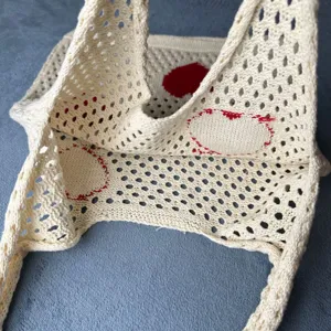 Nahaufnahme Detailansicht der cremefarbenen Strick Netztasche mit schönem rotem Herzmuster.