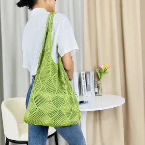 Detailansicht der gruenen gestrickten Mesh-Tragetasche, zeigt Textur und laessigen Tagesstil.