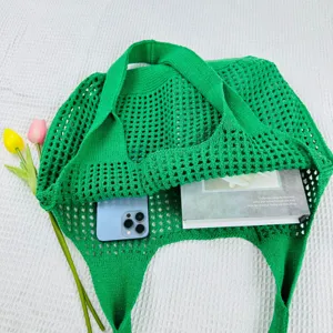 Detailaufnahme der grünen gestrickten Beuteltasche mit feiner Webstruktur undlässigem Stil.