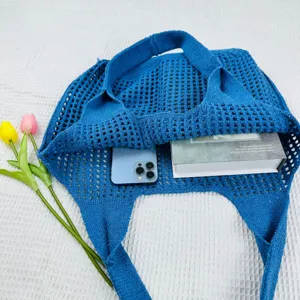 Blaues gestricktes Loch-Tote-Bag-Detail, lässige Netztasche mit schicker Webtextur.