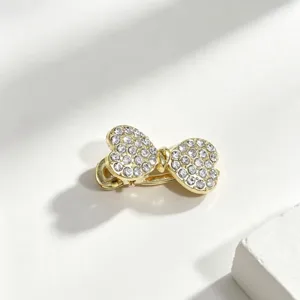 Primo piano di una forcina con fiocco in strass scintillanti, dettaglio metallo brillante.