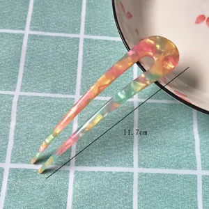 Close-up detail of the colorful acetate U-shaped hair fork, elegant tortoiseshell pattern.