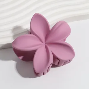Matte pink plumeria flower hair claw clip detail shot, perfect for summer hairstyles and daily wear.