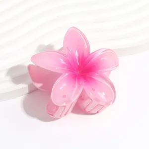 Close-up detail of a cute pink plumeria flower hair claw clip with jelly gradient finish.