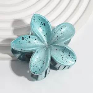 Detailed view of the blue pearl frangipani flower hair claw clip, fashion summer accessory.