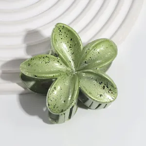 Close-up detail of green pearl plumeria hair claw clip, featuring unique speckled pattern.