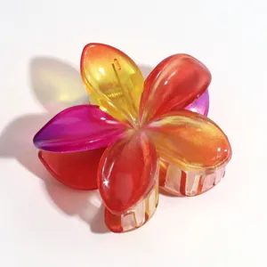 Colorful gradient plumeria hair claw clip, translucent jelly flower hair accessory detail view.