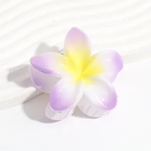 Detail shot of a pearl gradient plumeria flower hair claw clip in jelly purple and yellow.
