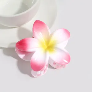 Detail view of a cute jelly pink plumeria flower hair claw clip for summer style.