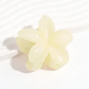 Plumeria jelly hair claw clip detail close-up, translucent yellow flower hair accessory.