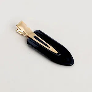 Dettaglio molletta per capelli a goccia unicolore minimalista, elegante design nero e oro quotidiano.