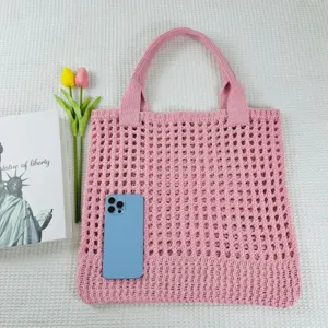 Rosa Strick Handtasche Detailansicht, zeigt das hohle Gitterdesign und weiche Garntextur.