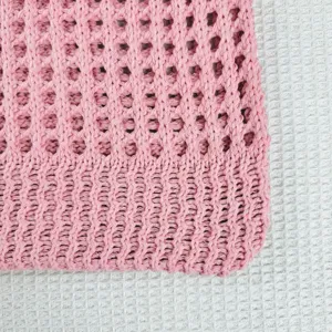 Nahaufnahme der rosa Strick-Hohl-Schultertasche, die feine Webtextur und Handwerkskunst zeigt.