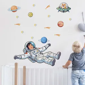 Detail view of cartoon astronaut and planet wall stickers applied in children bedroom.