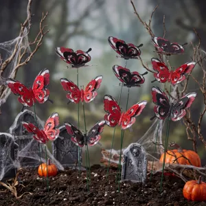 Gedetailleerd uitzicht op Halloween vlindertuinpennen met rode glitters en enge kerkhofrekwisieten.