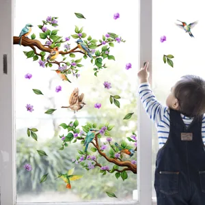 Détail de sticker de fenêtre avec des oiseaux et fleurs colorés sur verre, décor enfantin.