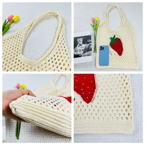 Nahaufnahme der geflochtenen Strick-Tasche mit rotem Erdbeer-Muster und praktischem Griff.