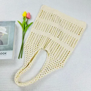 Beige gestrickte Beuteltasche Detailansicht, zeigt die Netztextur und das geraeumige Design.