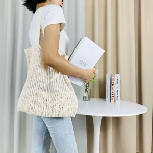 Detailed view of a chic beige knitted hollow-out shoulder tote bag for casual beach wear.