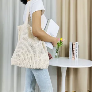 Detailed view of the beige knit tote bag showcasing its hollow out texture and large capacity.