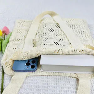 Gepflegte Strick-Tasche Detailansicht mit Lochmuster und grossem Stauraum mit Handy.