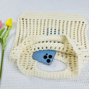 Vue détaillée d'un sac cabas en tricot beige ajouré, avec une texture en maille pour plage.