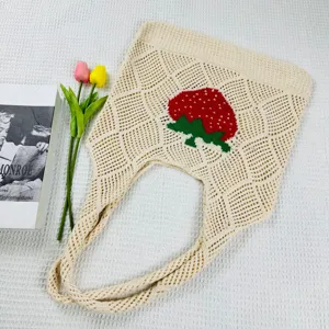 Nahaufnahme der beigen Stricktasche mit süßem rotem Erdbeermuster und tollem Lochstrickdesign.