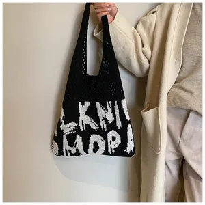 Nahaufnahme der Strick-Tasche mit schwarz-weißem Buchstabenmuster und feiner Netz-Struktur.