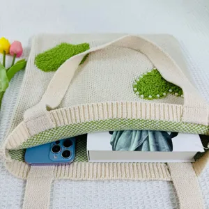 Detailansicht der gestrickten Tasche mit grünem flauschigen Muster und Perlendekor.
