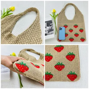 Detailopnames van de gebreide aardbeien tas, met fijne geweven textuur en handvatten.