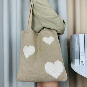 Detailansicht der beigen Strick-Tasche mit süßen weißen Herzen für den perfekten Alltags-Look.