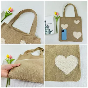 Detailaufnahme der modischen gestrickten Tasche mit niedlichem weißen Plüschherz-Muster.