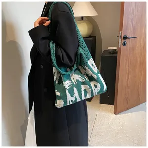 Detailansicht der grünen Strick-Tragetasche mit stylischem Buchstabenmuster für den Alltag.