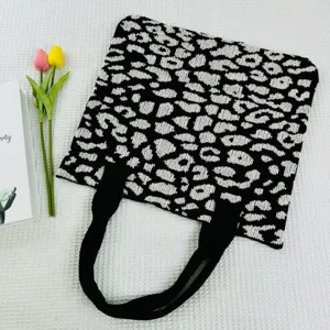 Nahaufnahme der schwarz-weißen Leopardenmuster Strick-Tasche mit feiner Textur und Details.