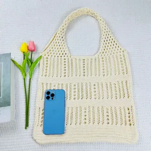 Detailansicht der beigen, gehäkelten Beuteltasche mit luftigem Lochmuster-Design.