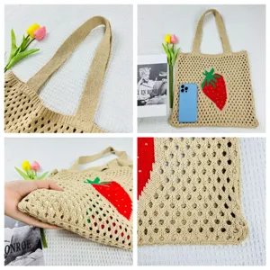 Detailansicht der gestrickten Beuteltasche mit süßem Erdbeermuster und robusten Griffen.
