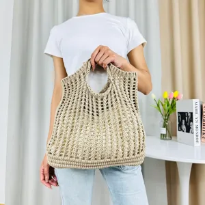 Vue détaillée du sac cabas beige en tricot ajouré, mettant en valeur la texture fine et les anses.