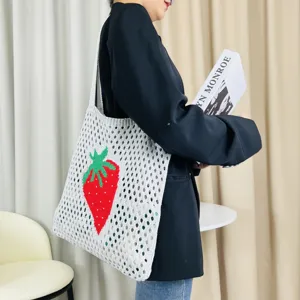 Detailansicht der süßen gestrickten Netztasche mit leuchtend rotem Erdbeermuster.