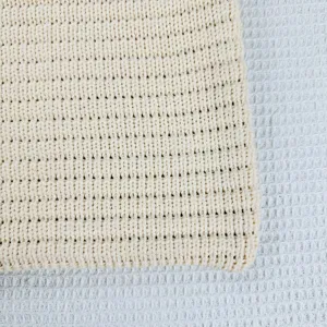 Primo piano dettagliato della texture del tessuto in maglia beige, mostrando alta qualita.